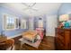 Comfortable bedroom featuring hardwood floors, shuttered windows, a ceiling fan and a decorative antique settee at 514 Riviera Dr, Tampa, FL 33606