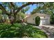 Charming home exterior featuring mature trees, lush landscaping, and a well-maintained lawn at 514 Riviera Dr, Tampa, FL 33606