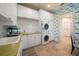 Well-equipped laundry room with stacked washer/dryer, ample storage, and charming car-themed wallpaper at 514 Riviera Dr, Tampa, FL 33606