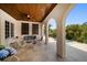 Relaxing covered patio with wood ceiling, view of a waterfront pool, and elegant architectural details at 514 Riviera Dr, Tampa, FL 33606