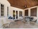 Elegant covered patio with detailed woodwork ceiling, stylish furniture, and serene outdoor living space at 514 Riviera Dr, Tampa, FL 33606