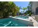 Inviting backyard pool and spa surrounded by lush tropical landscaping and a sunbathing deck with lounge chairs at 514 Riviera Dr, Tampa, FL 33606