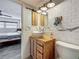 Modern bathroom with rustic vanity, subway tiles, and view into adjacent bedroom at 602 Mindy Dr, Largo, FL 33771