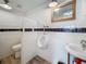 Stylish half bath features modern fixtures, white tile, and a wood-framed mirror at 602 Mindy Dr, Largo, FL 33771