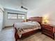 Bedroom with wood-look tile flooring, ceiling fan, and a window overlooking the neighborhood at 602 Mindy Dr, Largo, FL 33771