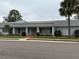 Inviting clubhouse featuring a grey roof, manicured lawn, and well-maintained landscaping at 602 Mindy Dr, Largo, FL 33771