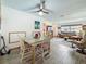 Open-concept dining room and living room featuring wood-look tile floors and a ceiling fan at 602 Mindy Dr, Largo, FL 33771