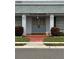 Close-up of clubhouse entrance featuring decorative double doors, sconce lighting and professional landscaping at 602 Mindy Dr, Largo, FL 33771