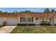 Exterior view of a home showing garage, small front yard, and well-kept landscaping at 602 Mindy Dr, Largo, FL 33771