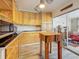Bright kitchen with black countertops, natural wood cabinets, an island, and sliding glass doors at 602 Mindy Dr, Largo, FL 33771