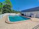 Community pool featuring clear, blue water surrounded by brick pavers, lounge chairs and a white fence at 602 Mindy Dr, Largo, FL 33771