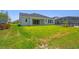 Grassy backyard with views of neutral-toned home, black fence, and enclosed pool area for outdoor living at 6126 Hidden Branch Dr, Apollo Beach, FL 33572