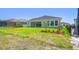 Lush backyard showcases a neutral-toned home with large windows, complemented by a black fenced-in pool at 6126 Hidden Branch Dr, Apollo Beach, FL 33572