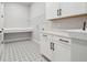 Well-lit laundry room with white cabinets, countertops, sink, and patterned floors at 6126 Hidden Branch Dr, Apollo Beach, FL 33572