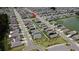 Wide aerial shot of a neighborhood with rows of houses and a nearby pond at 6444 Bar S Bar Trl, Zephyrhills, FL 33541