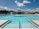 Community pool featuring clear blue water, ample lounge chairs, and shallow step entry at 6444 Bar S Bar Trl, Zephyrhills, FL 33541