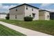 Home exterior featuring a neutral color scheme and a well manicured lawn at 6444 Bar S Bar Trl, Zephyrhills, FL 33541