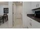 Hallway leads to laundry room with white cabinets, gray countertop and an adjacent dining room at 6444 Bar S Bar Trl, Zephyrhills, FL 33541
