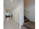 Bright hallway with tile flooring, leading to a cozy living room and stairs to the second floor at 6444 Bar S Bar Trl, Zephyrhills, FL 33541