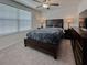 Bedroom featuring a dark wood bed frame and dresser, illuminated by table lamps at 6444 Bar S Bar Trl, Zephyrhills, FL 33541