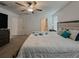 Bright main bedroom with a ceiling fan, large windows, and an ensuite bathroom at 6444 Bar S Bar Trl, Zephyrhills, FL 33541