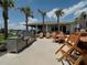 Outdoor kitchen features a grill and dining area surrounded by palm trees for an island feel at 6444 Bar S Bar Trl, Zephyrhills, FL 33541