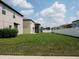 Back yard featuring a large green lawn, a white fence, and homes nearby at 6444 Bar S Bar Trl, Zephyrhills, FL 33541