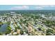 A wide aerial shot of a neighborhood emphasizing the density of homes and greenery in a suburban landscape, a pin indicates the address at 6875 11Th N Ave, St Petersburg, FL 33710