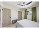 Comfortable bedroom featuring a ceiling fan, closet space, and a window with green curtains at 6875 11Th N Ave, St Petersburg, FL 33710