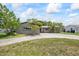 Landscaped home exterior with a curving driveway and vibrant flowering trees at 6875 11Th N Ave, St Petersburg, FL 33710