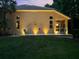 Picturesque backyard featuring an outdoor patio, a lush green lawn, and ambient lighting at 7246 Gaberia Rd, New Port Richey, FL 34655