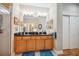 Bright bathroom with a double sink vanity, framed mirrors, and a walk-in shower with glass door at 7246 Gaberia Rd, New Port Richey, FL 34655