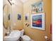 Well-lit powder room featuring contemporary sink fixtures, framed artwork, and a charming decorative accent at 7246 Gaberia Rd, New Port Richey, FL 34655