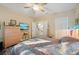 Comfortable bedroom featuring colorful bedding, wood-look flooring, and a modern ceiling fan at 7246 Gaberia Rd, New Port Richey, FL 34655