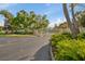 Community entrance gate with mature trees and lush landscaping creates a welcoming first impression at 7246 Gaberia Rd, New Port Richey, FL 34655