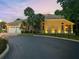 Elegant home with a three-car garage, lush landscaping, and inviting outdoor lighting at 7246 Gaberia Rd, New Port Richey, FL 34655