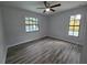 Bedroom with wood floors, ceiling fan, and dual windows at 7278 Radcliff St, Spring Hill, FL 34606