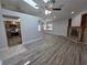 Spacious living room featuring wood flooring, a fireplace, and an open layout into the kitchen at 7278 Radcliff St, Spring Hill, FL 34606