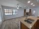 Bright open-plan living room seamlessly connected with the kitchen featuring wooden cabinets and granite counters at 7278 Radcliff St, Spring Hill, FL 34606