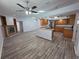 Spacious living room with hardwood floors, fireplace and seamlessly connected to the modern kitchen with island at 7278 Radcliff St, Spring Hill, FL 34606
