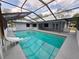 A covered outdoor pool area with a slide, lounge area, and screened enclosure at 7278 Radcliff St, Spring Hill, FL 34606