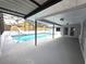 A covered outdoor pool area with a slide, lounge area, and screened enclosure at 7278 Radcliff St, Spring Hill, FL 34606