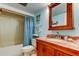 Charming bathroom featuring a wooden vanity with marble countertop and a shower tub with curtains at 7465 Bay Island S Dr # 213, South Pasadena, FL 33707