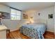 Bright bedroom with hardwood floors, a large window, and a comfortable bed with floral patterned bedding at 7465 Bay Island S Dr # 213, South Pasadena, FL 33707