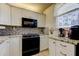 Functional kitchen featuring sleek black appliances, granite countertops, stylish backsplash, and plenty of cabinet space for storage at 7465 Bay Island S Dr # 213, South Pasadena, FL 33707