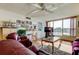 Cozy living room with a ceiling fan, hardwood floors, comfortable seating, and a large window offering picturesque water views at 7465 Bay Island S Dr # 213, South Pasadena, FL 33707