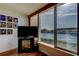 Sunlit living room boasting scenic waterfront views through a large window, accented with hardwood floors and a sleek TV setup at 7465 Bay Island S Dr # 213, South Pasadena, FL 33707