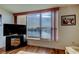 Bright living room featuring a large window showcasing scenic waterfront views, complemented by hardwood floors and a TV at 7465 Bay Island S Dr # 213, South Pasadena, FL 33707