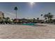 Community pool surrounded by palm trees and lounge chairs at 7465 Bay Island S Dr # 213, South Pasadena, FL 33707