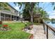 Backyard features a fire pit, lush lawn, screened in porch, and waterfront tree house at 8203 Kirkwood Dr, Tampa, FL 33634